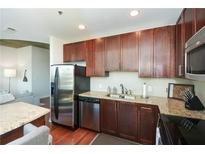 Modern kitchen with stainless steel appliances, granite countertops, and wood floors at 855 Peachtree Ne St # 2412, Atlanta, GA 30308