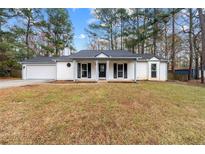 Charming single-story home with a covered front porch and attached garage at 489 Natasha Dr, Auburn, GA 30011