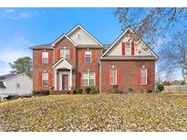 Red brick two-story home exterior with a covered entryway and landscaped yard at 4894 Brown Leaf Dr, Powder Springs, GA 30127