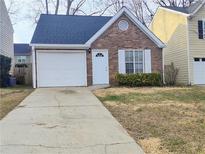 Charming brick home with attached garage and landscaped front yard at 1040 Hillsborough Chase Nw, Kennesaw, GA 30144