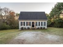 Beige house with black shutters, a gray roof, and a small yard at 4948 Emmett Still Rd, Loganville, GA 30052