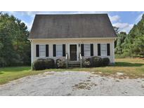 Charming single-story home with a gravel driveway and landscaping at 4948 Emmett Still Rd, Loganville, GA 30052