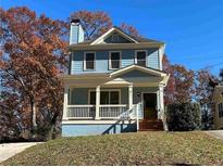 Charming blue two-story home with a front porch and grassy yard at 941 Capitol View Ave, Atlanta, GA 30318