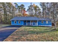 Charming blue home with a covered front porch, paved driveway, and grassy front yard at 25 Salem Branch Ct, Covington, GA 30016