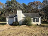 Charming single-story home with a chimney, attached garage, and front yard at 4262 Catalpa Park, Ellenwood, GA 30294