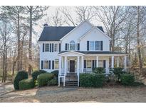 Two-story white house with black shutters, porch, and landscaping at 540 Westchester Club Dr, Hiram, GA 30141