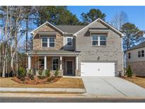 Inviting two-story home with a charming front porch and a two-car garage at 1495 Auburn Glen Rd, Dacula, GA 30019