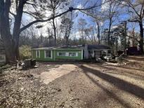 Green single-story home with brick walkway and wooded lot at 202 Hayes St, Villa Rica, GA 30180
