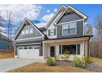 Charming two-story home with a gray and white exterior, front porch, and attached garage at 454 Boulder Crest Trl, Villa Rica, GA 30180