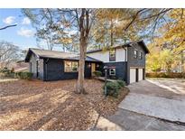 Modern two-story home with dark gray brick exterior, white siding, and attached garage at 1986 Twin Falls Rd, Decatur, GA 30032