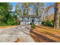 Charming two-story home with a driveway, front yard, and trees at 3930 Wedgefield Cir, Decatur, GA 30035