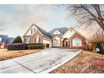 Charming two-story brick home with a long driveway and landscaped yard at 907 Hannah Ct, Loganville, GA 30052