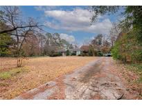 Single-story home with driveway, front yard, and trees at 750 Mount Vernon Hwy, Atlanta, GA 30327