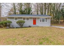 Charming single-story home with a red door and gray brick exterior at 453 Utoy Sw Cir, Atlanta, GA 30331