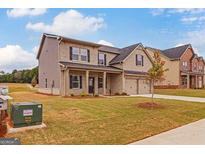 Two-story home with brick exterior, front yard landscaping, and attached two-car garage at 1628 Fuma Leaf Way, Mcdonough, GA 30253