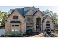 Stately brick home with arched entryway and manicured landscaping at 3229 Carmichael Pl, Duluth, GA 30097