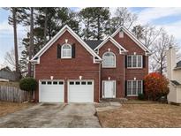 Charming two-story brick home with a two-car garage and landscaped yard at 1547 Welch Ct, Suwanee, GA 30024