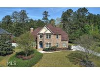 Charming two-story brick home with a landscaped yard and mature trees at 3213 Ashmore Ct, Conyers, GA 30094