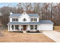 Charming two-story home with a front porch, driveway, and attached garage at 128 Garrison Dr, Dallas, GA 30157