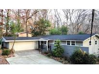 Charming two-story home with attached garage, landscaped yard, and trees at 3479 Chestnut Dr, Atlanta, GA 30340