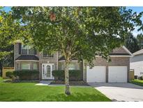 Inviting two-story home with a lush green lawn, brick exterior, and attached two-car garage at 6665 Pine Valley Trce, Stone Mountain, GA 30087