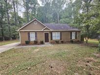 Charming single-story home with a landscaped front yard and trees at 8095 Flamingo Dr, Jonesboro, GA 30238