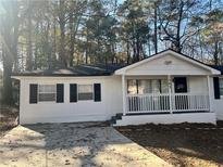 Charming white home with black shutters and covered front porch at 1543 California Ave, Conley, GA 30288