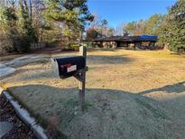 Front yard view of a single-story home with a mailbox and a large lawn at 4956 Great Meadows Rd, Lithonia, GA 30038