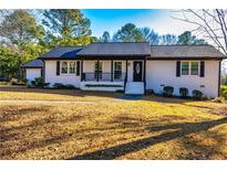 White brick ranch house with black accents, a covered porch, and a well-manicured lawn at 3625 Pointer Rd, Loganville, GA 30052