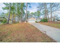 Charming two-story home with driveway, grassy front yard, and trees at 5136 Huxley Rd, Stone Mountain, GA 30088