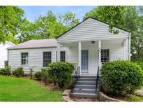 Charming white home with covered front porch, landscaping, and steps leading to the entrance at 2454 Spring Garden Sw Dr, Atlanta, GA 30315