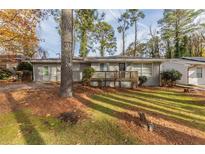 Charming single-story home with a wooden deck, surrounded by trees at 1852 Shamrock Dr, Decatur, GA 30032