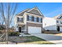 Two-story house with gray siding, brick accents, and a two-car garage at 9004 Jim Purcell Dr, Covington, GA 30014