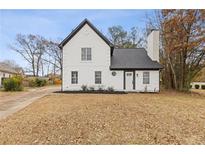 Charming two-story home with a white exterior, dark roof, and landscaping at 988 Boardwalk Dr, Lawrenceville, GA 30044