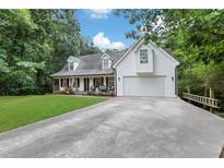 Charming two-story home with a front porch, lush lawn, and attached garage at 4378 Ridge Ct, Loganville, GA 30052