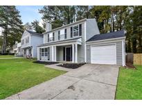 Charming two-story home with a gray exterior, white trim, and attached garage at 1344 Mill Lake Cir, Stone Mountain, GA 30088