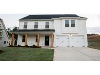 Charming two-story home with white brick exterior, wooden columns, and a two-car garage at 333 Orwell Dr, Social Circle, GA 30025