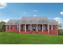 Red brick home with white columns and a green lawn under a blue sky at 2984 Berry Rd, Loganville, GA 30052