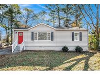 Charming ranch home with a red door and well-manicured lawn at 1786 Ledo Ave, Decatur, GA 30035
