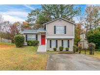 Two-story house with red door, landscaping, and driveway at 3972 Glenwood Downs Ln, Decatur, GA 30035