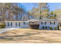 Gray brick ranch house with a landscaped yard and driveway at 8661 Chestnut Ln, Lithia Springs, GA 30122