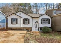 Newly renovated home with white siding, black shutters, and a landscaped yard at 1358 To Lani Farm Rd, Stone Mountain, GA 30083