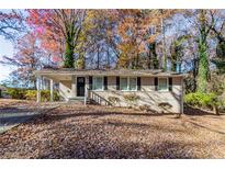 Tan brick ranch home with a covered carport and steps leading to the front door at 2329 Meadowlane Sw Dr, Atlanta, GA 30311