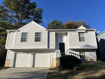 Two-story house with white siding, attached garage, and landscaping at 6268 Marbut Farms Trl, Lithonia, GA 30058