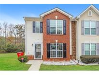 Brick front townhouse with landscaping, two-story, and a small front yard at 8409 Carlington Ln, Jonesboro, GA 30236