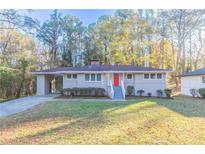 Charming ranch home with red door and well-manicured lawn at 2836 Hedgewood Nw Dr, Atlanta, GA 30311
