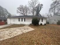 White Ranch home with a spacious yard and driveway at 4887 Glenwood Rd, Decatur, GA 30035