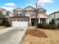 Two-story house with stone and siding, white garage door, and landscaping at 422 Mcdaniel Pl, Canton, GA 30115