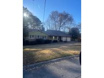 Ranch style home with a green exterior, large yard, and attached garage at 3262 Carriage Way, Marietta, GA 30062