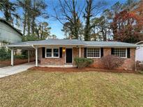 Brick ranch house with carport, landscaping, and a well-maintained lawn at 2891 Hedgewood Nw Dr, Atlanta, GA 30311